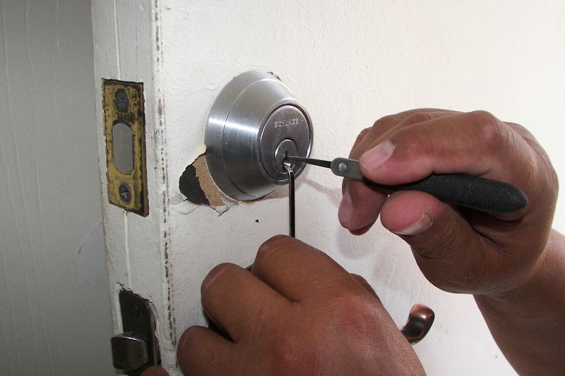Locksmith working on a deadbolt lock in a door